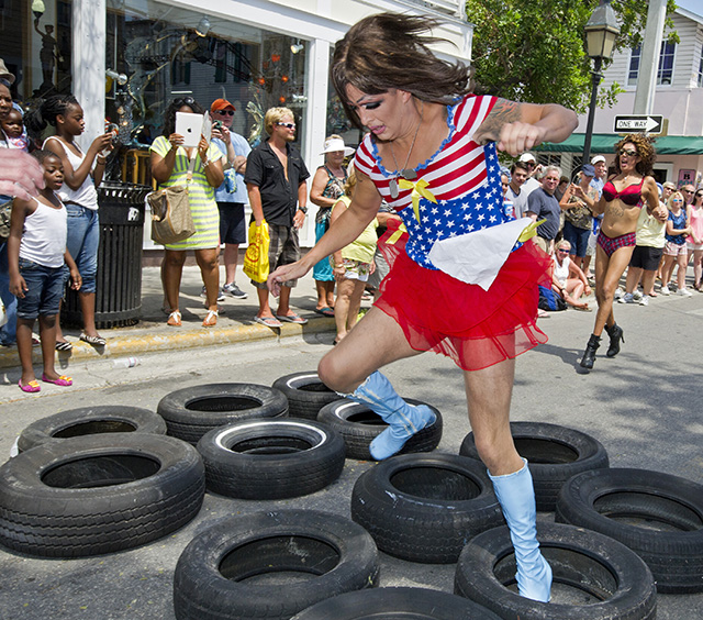 In this Saturday, April 20, 2013, photo provided by the Florida Keys News Bureau, a female impersonator high-steps through tires after being pushed in a shopping cart during the Great Conch Republic Drag Race in Key West, Fla. The hijinks was a facet of the 10-day Conch Republic Independence Celebration that continues through April 28 and marks the Florida Keys 1982 