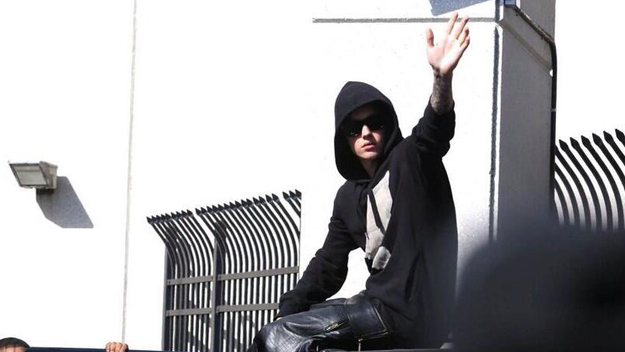 MIAMI - Justin Bieber waves to the crowd of photographers and fans gathered outside the TGK detention center after he was released from jail. (Source: Hector Gabino/El Nuevo Herald)