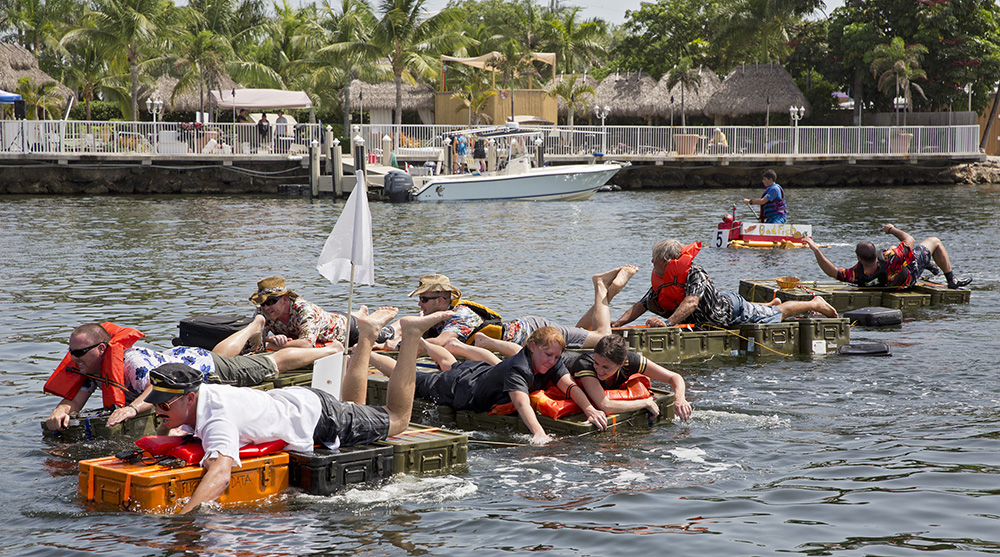 Competitors in the Anything That Floats Race, propel their Flight From Hell entry Saturday, Aug. 16, 2014, in Key Largo, Fla. This watercraft was created from strapped-together, metal military cases tied together with rope. The offbeat event in the Florida Keys challenged entrants to race in whatever they could find or build that provided buoyancy.  (Bob Care/Florida Keys News Bureau/HO)