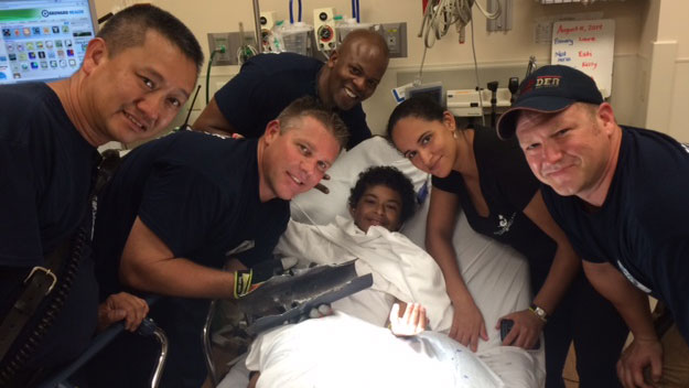 Firefighters pose with a boy who had his finger freed from a pipe.  (Photo source: FLFD)
