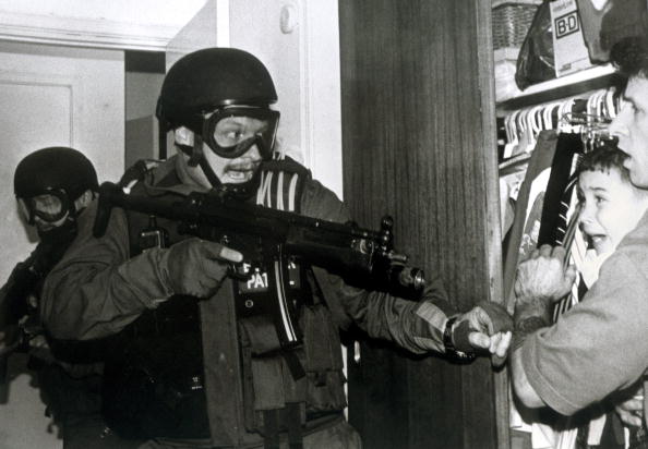 This photograph released 16 April 2001 by Columbia University in New York and taken by Alan Diaz of the Associated Press, which won the Pulitzer Prize for Breaking News Photography. The photo shows Cuban refugee Elian Gonzalez and Donato Dalrymple (R) in a bedroom closet as federal agents enter the Miami home of Elian's relatives and was taken 22 April 2000.  (Photo credit: ALAN DIAZ/AFP/Getty Images)