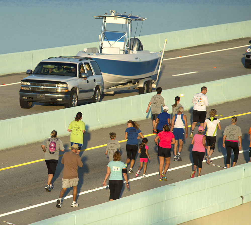 An SUV, trailering a boat, passes competitors in the Key Largo Bridge Run Saturday, Nov. 8, 2014, in Key Largo, Fla. The event attracted 771 participants who competed in 5K, 10K or half-marathon divisions. During the run, traffic from the Keys to the South Florida mainland was diverted to an alternate route. Traffic to the Keys was not impacted by the event.  (Andy Newman/Florida Keys New Bureau/HO)