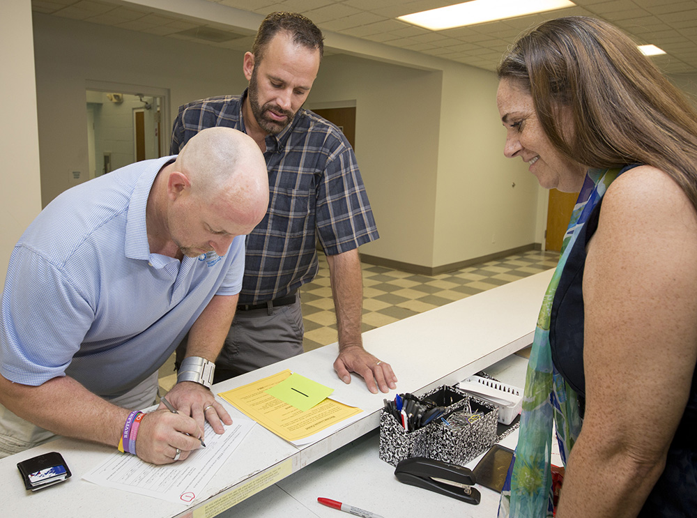 William Lee Jones, left, and Aaron Huntsman, center, complete a marriage license application at the Monroe County Courthouse Friday, Jan. 2, 2015, in Key West, Fla. At right is Amy Heavilin, Monroe's clerk of the court. Jones and Huntsman are planning on receiving their license just after midnight Monday, Jan. 5, and getting married immediately afterwards. In July 2014, after Huntsman and Jones filed suit protesting Florida's 2008 ban on same-sex marriage, Keys j Judge Luis Garcia ruled the ban was discriminatory and unconstitutional. A state appeal held up the couple's marriage plans until U.S. Judge Robert Hinkle ruled Florida clerks can issue licenses to same-sex couples beginning after midnight Monday. (Andy Newman/Florida Keys News Bureau/HO)