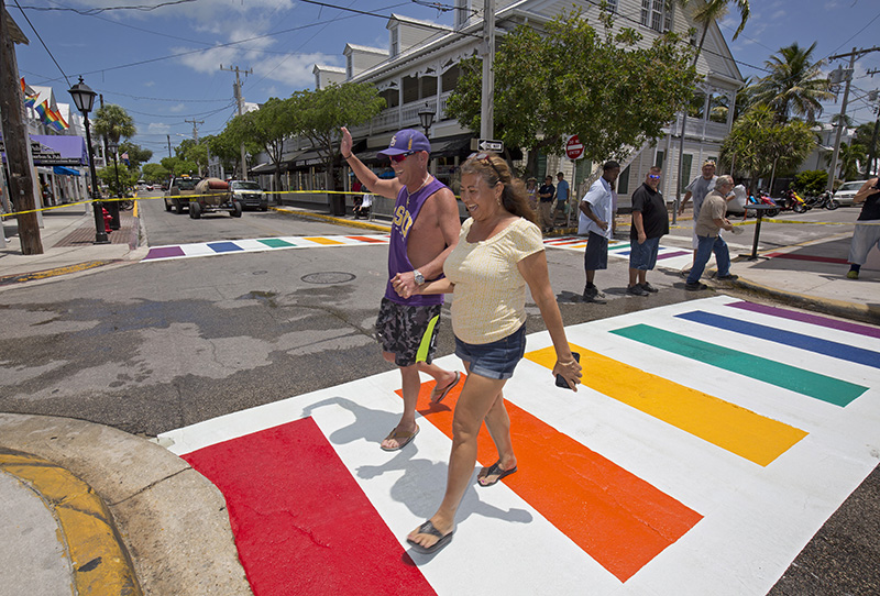 Gary Salazar, left, and Maria Walden, right, are the first to tread across Duval Street in Key West, Fla., on a new rainbow crosswalk just after four were installed at Duval and Petronia streets Thursday, May 28, 2015. The crosswalks feature bands of all six colors of the rainbow flag, an internationally recognized symbol of gay and lesbian unity. They are composed of pre-formed thermoplastic color blocks alternating with white stripes and heat-treated to become a permanent part of the pavement. (Rob O'Neal/Florida Keys News Bureau/HO)