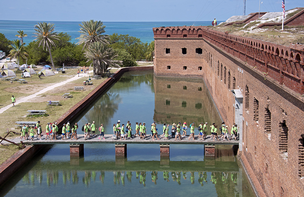 Descendants of Dr. Samuel A. Mudd walk into Fort Jefferson in Dry Tortugas National Park, Fla., Friday, July 24, 2015, to mark the 150th anniversary of Mudd's July 24, 1865, arrival at the isolated Gulf of Mexico fort where he was imprisoned after splinting the broken leg of President Abraham Lincoln's assassin. The former Union military prison lies 68 miles west of Key West, Fla. After serving four years in the prison, Mudd was pardoned, but repeated attempts by family members to have his conviction expunged have failed.  (Andy Newman/Florida Keys News Bureau/HO)