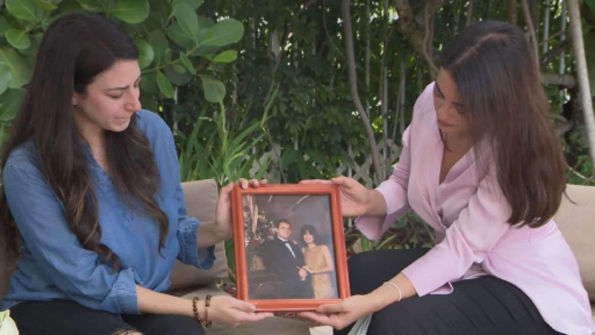 CBS4 reporrter Jessica Vallejo and another family member hold a photo featuring her uncle Charlie and his wife.